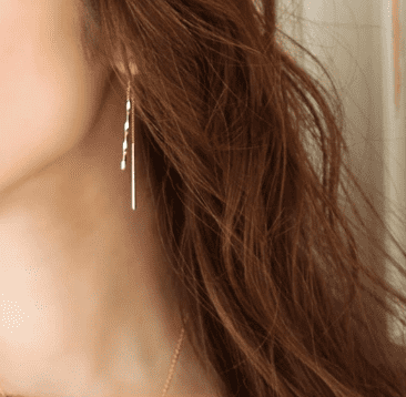 ゴールドの揺れるピアスを着けた女性